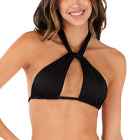 A person wearing the Nina Convertible Bikini Top, a versatile black halter neck bikini top handmade in Colombia, is smiling against a plain white background.