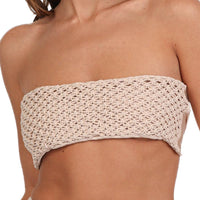 Someone is donning the Tia Macrame Strapless Bikini Top, a beige, crocheted piece that evokes beach fashion. The highlight is its intricate woven design, much like a handmade macrame bikini top, showcased against a simple background.