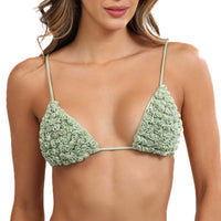 A woman dons the Katt Triangle Bikini Top, a piece from a lively swimwear collection. This bikini top is adorned with handcrafted mini rosettes, showcasing light green fabric with a floral pattern, complemented by thin strings and triangular cups.